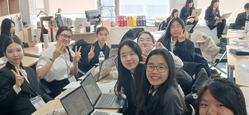 A group of students sit around a desk working on MUN