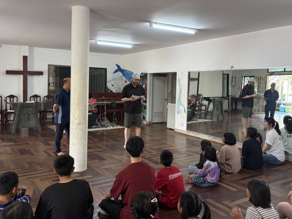 Person giving a sermon to a group of kids